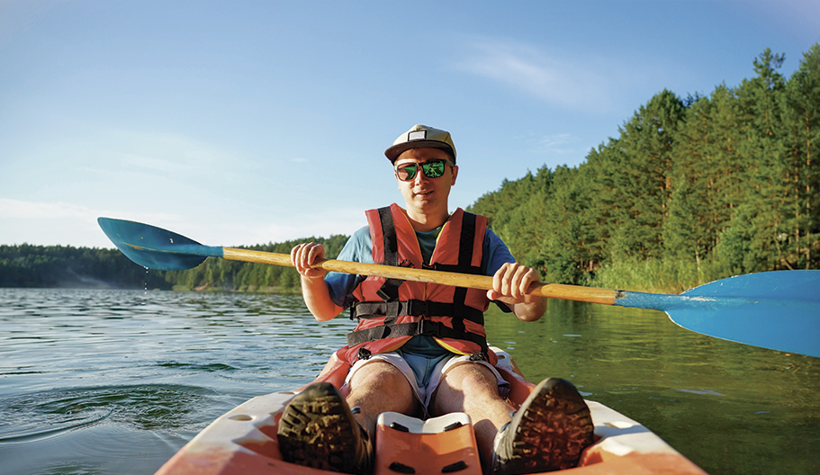 Chico disfrutando del verano en canoa con gafas polarizadas.