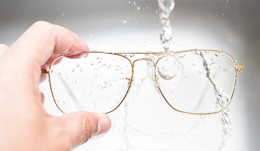 Persona limpiando sus gafas bajo el agua.