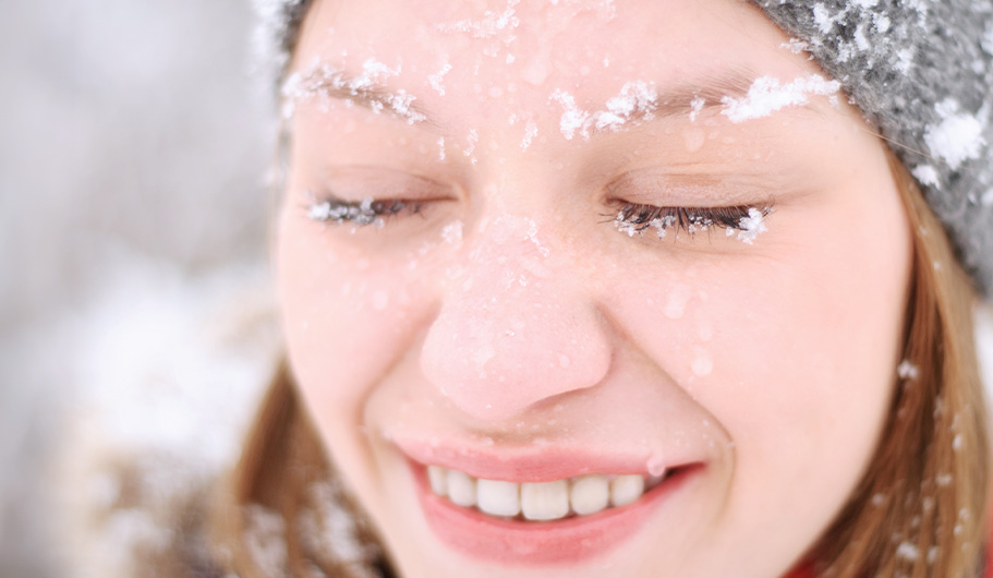 Chica con la cara cubierta de copos de nieve